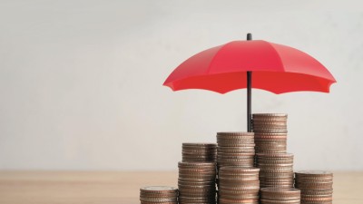 Ein Haufen Münzen unter einem kleinen roten Regenschirm auf einem Tisch