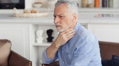 Senior hält sich vor Schmerzen an den Hals