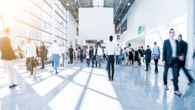 Menschen bewegen sich in Messehalle