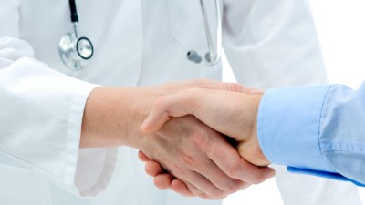 Arzt und Patient geben sich die Hand