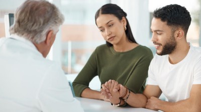 Couple consulting with doctor in clinic