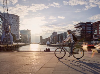 Hamburg young woman riding a bike (qbeyond-Advertorial)