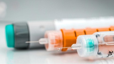 Image is a photograph of insulin injection needles and pen 