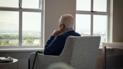Alter Mann im Sessel mit Blick aus dem Fenster