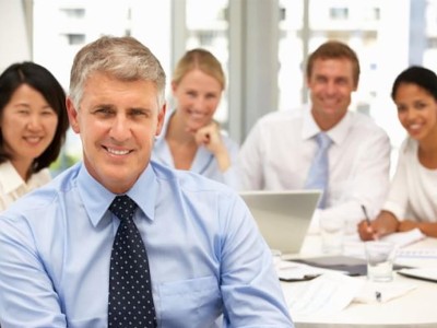 In die Kamera lächelnder Geschäftsmann bei einem Meeting. 