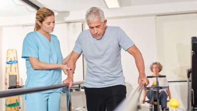 Mann beim Rehasport unterstützt von einer Frau