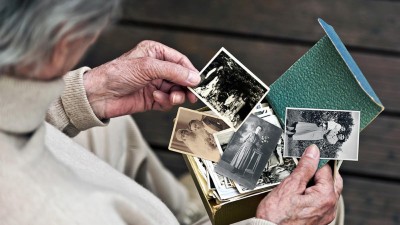 Seniorin betrachtet alte Fotos