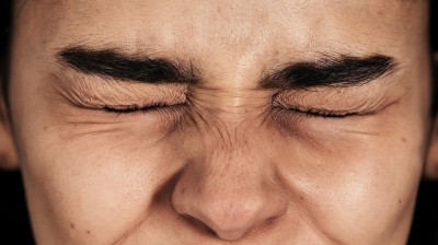 Gesicht mit zugekniffenen Augen und gerunzelter Stirn