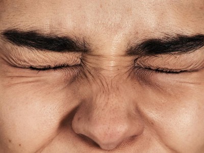 Gesicht mit zugekniffenen Augen und gerunzelter Stirn