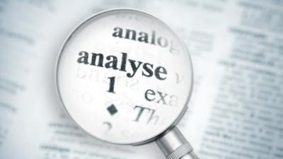 Eine Lupe vergrößert das Wort analyse.