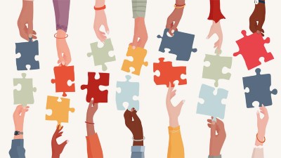 Group of raised arms of diverse people holding a jigsaw piece.
