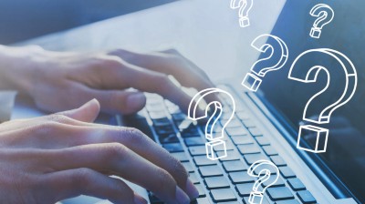 Finger auf einer Laptop Tastatur, Overlay mit Fragezeichen