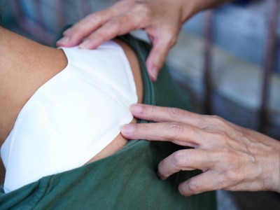 Wärmepflaster auf dem Nacken eines Mannes