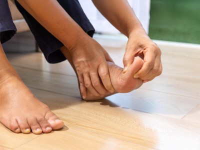 Frau hält sich den linken Fuß