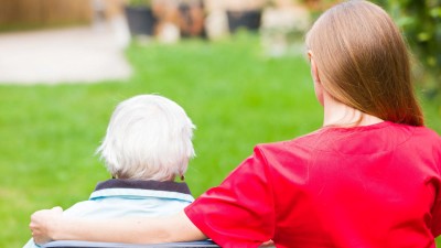 Ältere Dame im Rollstuhl mit Betreuungskraft