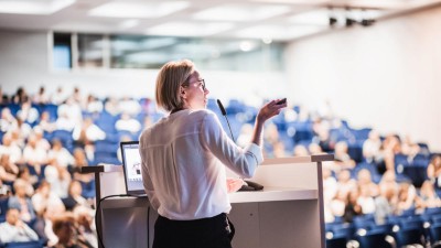 Frau hält Vortrag vor Kongresspublikum