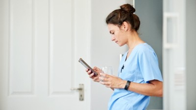 Ärztin guckt auf ihr Handy