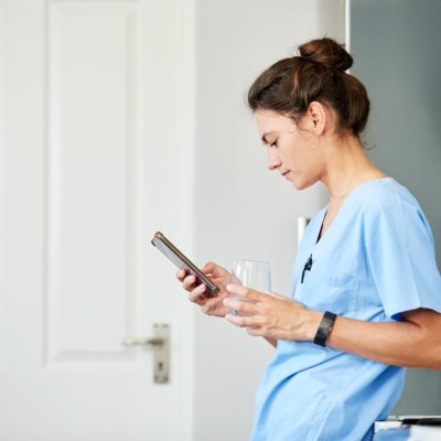 Ärztin guckt auf ihr Handy