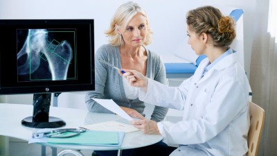 Teaserbild Ärztin mit Patientin im Gespräch vor Bildschirm