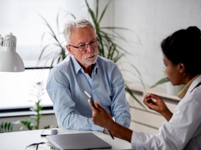 Alter Mann in Sprechstunde mit junger Ärztin