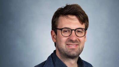 Dr. Jörg Dörrstein, ein braunhaariger Mann mit Brille und Dreitagebart. 