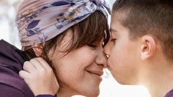 Junge küsst seine Mutter auf die Nase