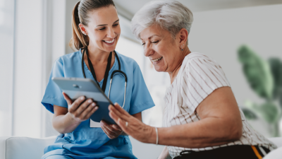 Ärztin zeigt Patientin etwas auf dem Tablet