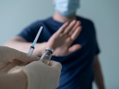 Mensch mit Maske lehnt Impfung ab