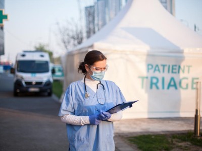 Junge Ärztin vor einem Triage-Zelt
