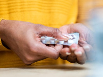 Close-up of person taking a pill out of a blister packet