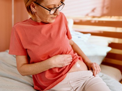 Frau in der Menopause mit Hormonpflaster