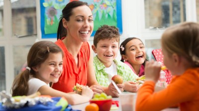 Kinder mit Lehrerin bei der Frühstückspause