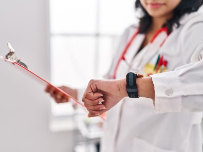 Ärztin blickt auf Uhr