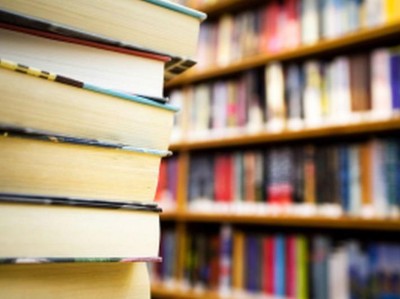 Ein Stapel Bücher vor einem Bücherregal