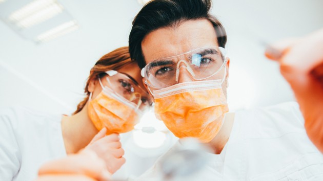 Two dentists in masks and goggles