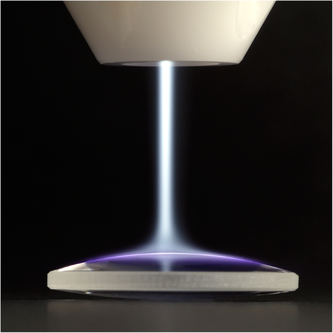 Interfacial modification of an artificial stem cell niche using CAP. Image was taken when using a handheld plasma device based on piezoelectric direct discharge (PDD) technology. The gaseous plasma jet can be seen exiting the nozzle and spreading over the target surface