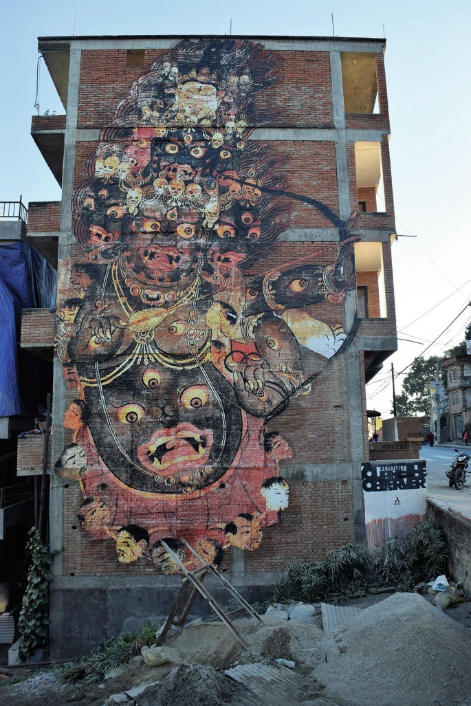 A photograph of a building wall with a mural of Mahakala.