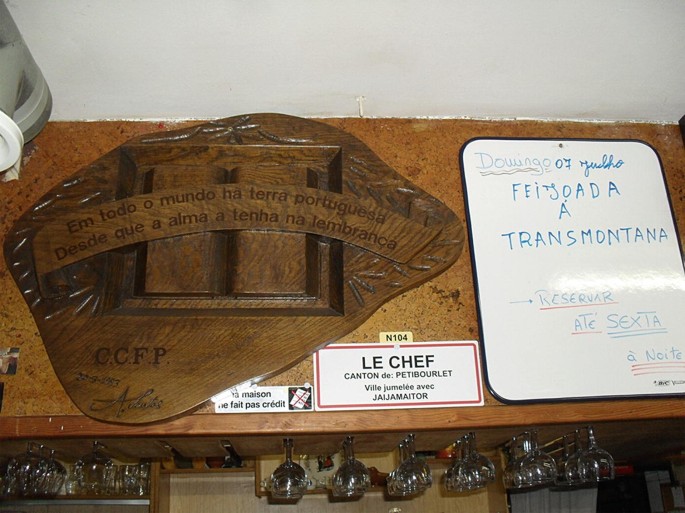 A photograph of a wooden rack with some wine glasses, along with a note that is a formal agreement between French and Portuguese authorities.