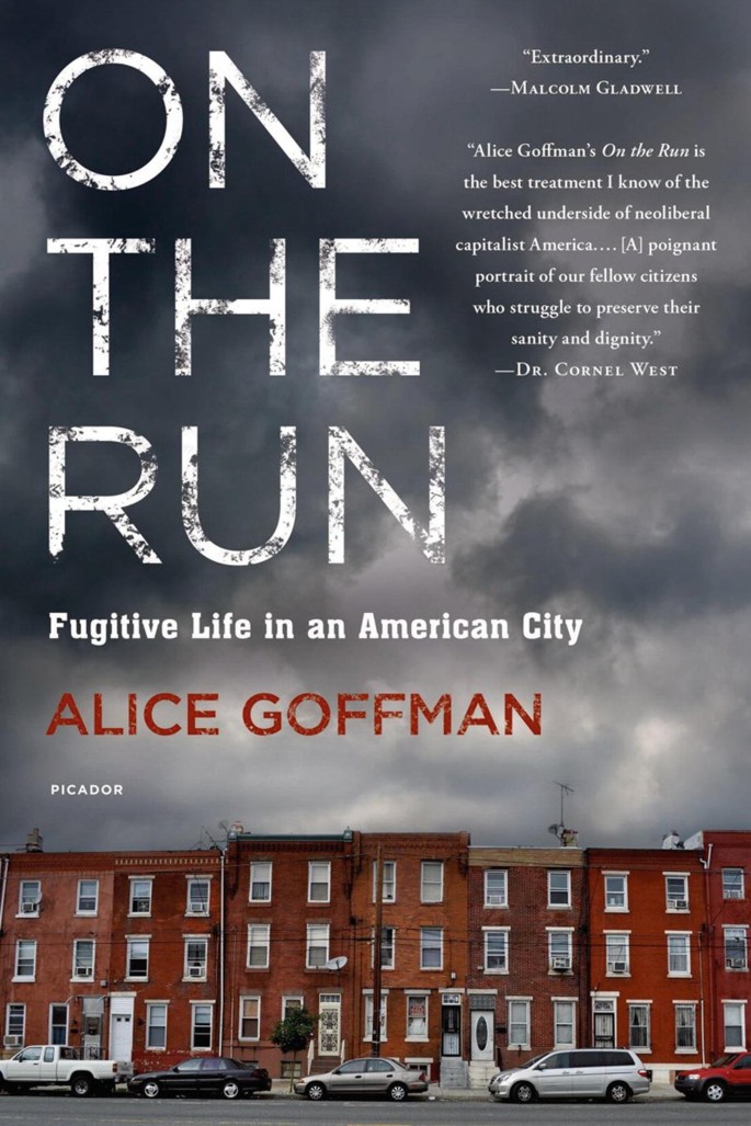 A photograph of the front cover page of a book titled, on the run, fugitive life in an American city, by Alice Goffman. A photograph below is of 3-storeyed town houses with cars parked in front.