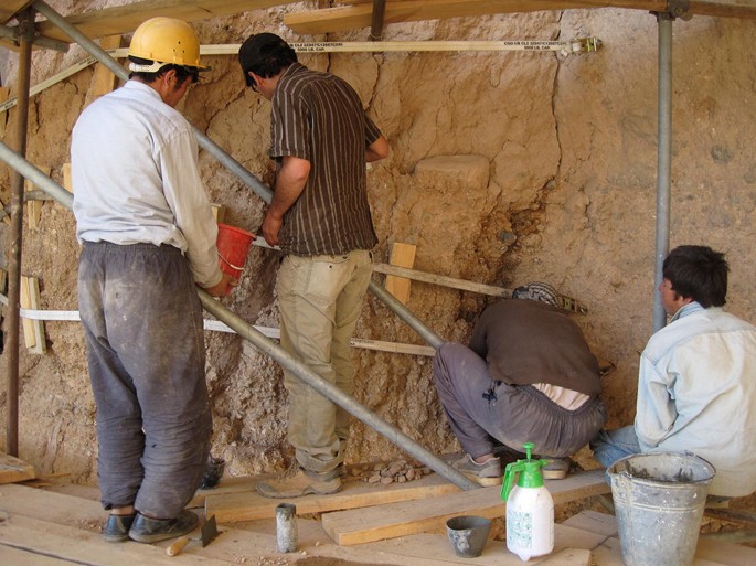 A photograph of four people working.