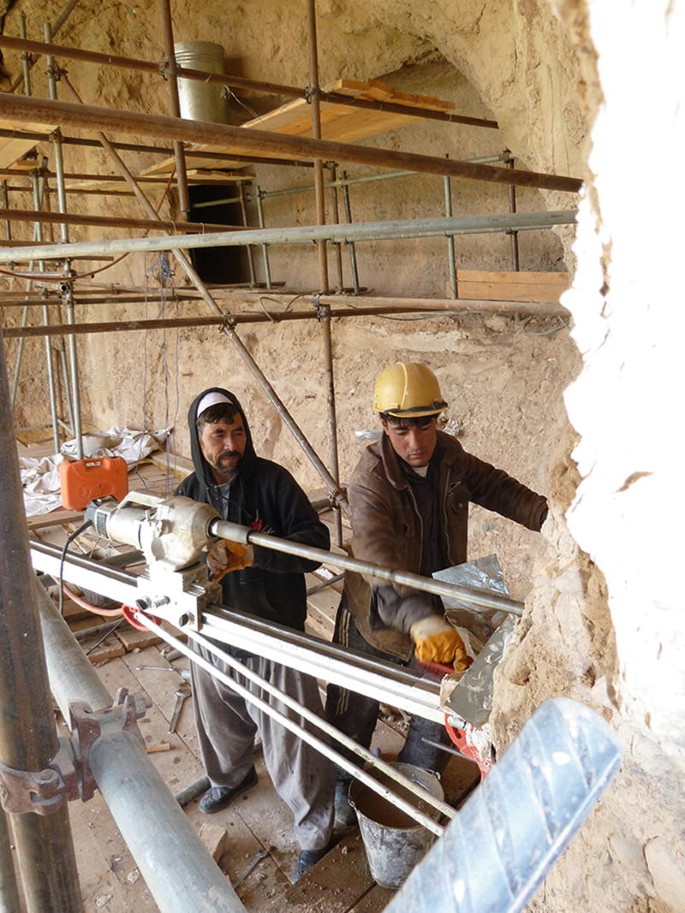 A photograph of two people working on a site.