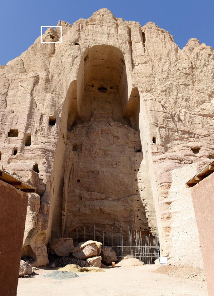 A photograph of a destroyed statue of Buddha of Bamiyan and a small square is placed in the upper left corner near a void.