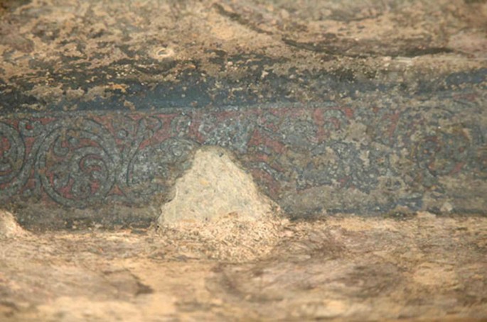A photograph of a vandalized pattern in the wall painting in a cave.