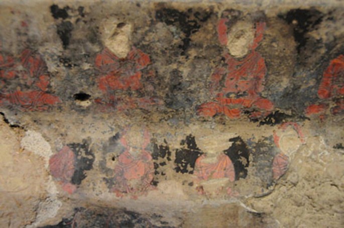 A photograph of a wall painting of Buddha figures in cave N. The eyes and hands of the Buddha were damaged.