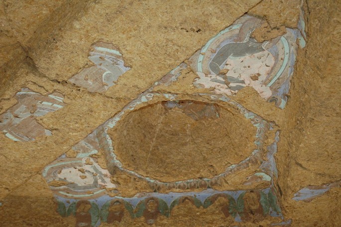 A close-up photograph depicts the wall paintings in Cave 4. A part of the painting is cut and looted.