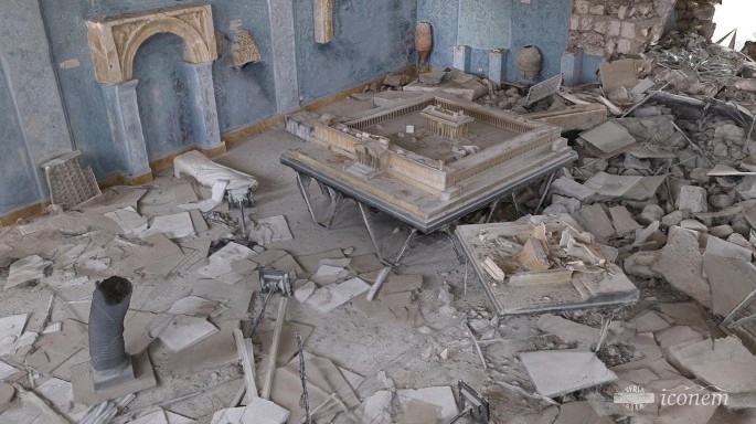 A photograph depicts the remains and debris scattered all over the floor of the destroyed museum of Palmyra.