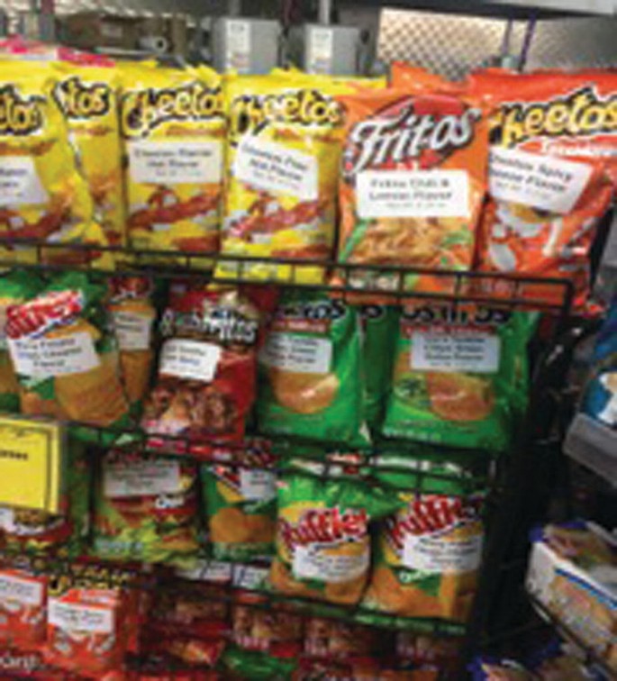 A photograph of a rack loaded with chip bags, each of which has a sticker with an English translation.