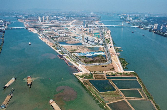 An aerial view of a district surrounded by water. The area of the district expands away from the port area.