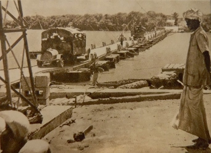 A distorted image of vehicles passing over a broken bridge.