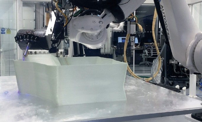 The image from the manufacturing site in which a hollow boat section is being made by the automatic machinery.